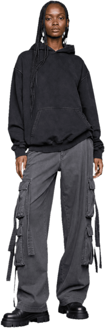 An oversized washed-black hoodie over wide grey cargo trousers with strapping, and heavy black boots